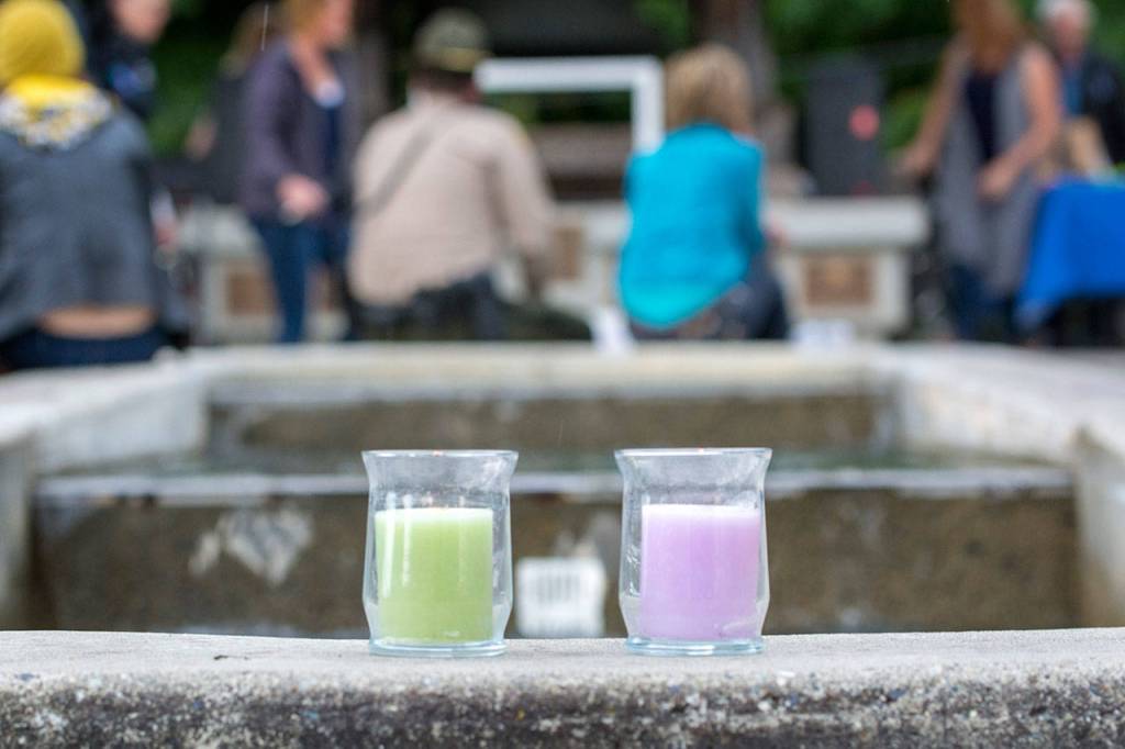 Candles sit on the edge of the fountain at Veterans Memorial Park in Port Angeles as a crowd gathers Monday for World Suicide Prevention Day. (Jesse Major/Peninsula Daily News)