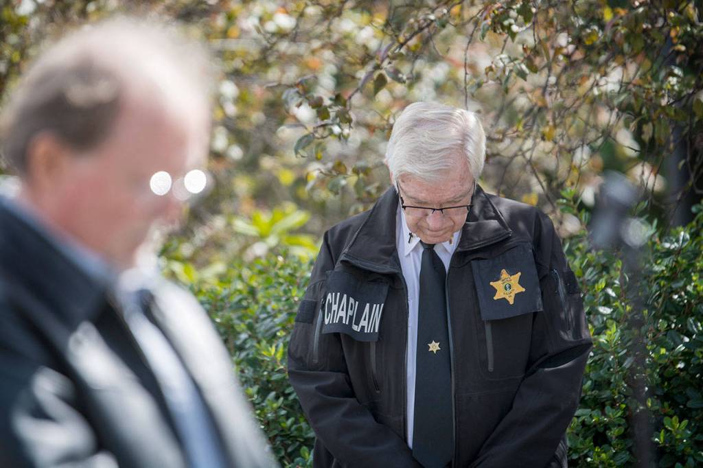 Clallam County Sheriffs Chaplain Ed Evans bows his head during a moment of silence for those who died during the 9/11 terrorist attacks. (Jesse Major/Peninsula Daily News)
