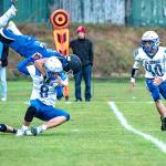 Chimacums Logan Storm flips over La Conners Brady Wyles (8) while making a tackle during Fridays game at Memorial Field in Port Townsend. AT right is La Conners Joseph Musni. (Steve Mullensky/for Peninsula Daily News)