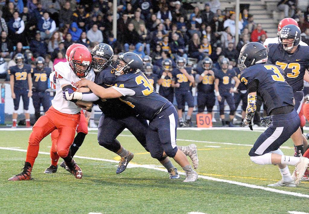 The Port Townsend Redhawks ran into a stingy defense Friday night in Forks as Spartans Iziah Morton and Tristen Pisani (34) stop Port Townsends Dylan Tracer for a loss while Brett Moody (3) and Luke Dahlgren close in. (Lonnie Archibald/for Peninsula Daily News)