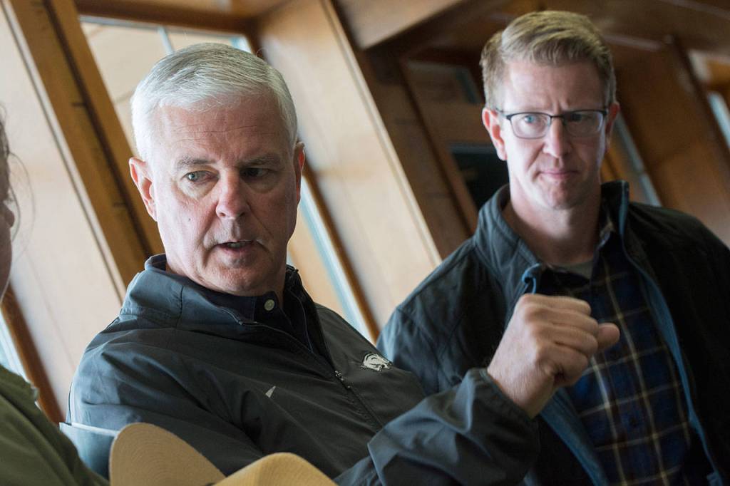 U.S. Reps. Steve Womak, left, and Derek Kilmer ask questions while visiting Hurricane Ridge on Sunday. (Jesse Major/Peninsula Daily News)