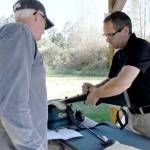 Mike Roth, range master at the Jefferson County Sportsmen Association range in Port Townsend helps Rick Kronquist of Marrowstone Island clean the carbon build up from his .50 caliber muzzleloader black powder rifle. (Jeannie McMacken/Peninsula Daily News)