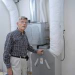 David Large describes the functions of a heat recovery ventilator that transfers warm or cool air trough his energy-efficient house. (Keith Thorpe/Peninsula Daily News)