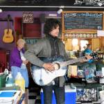Torren Snyder plays one of the original guitars at the Boiler Room during a rummage sale to liquidate assets. The youth-oriented venue has closed its operations and the building will be sold. Another sale will be held Saturday. The board of directors plan to ask the youth in the community what they want the next version of the Boiler Room to become. (Jeannie McMacken/Peninsula Daily News)