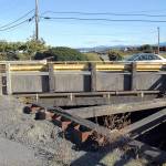 A car crosses a short bridge spanning a canal that connects the lagoon near the McKinley Paper mill in Port Angeles with the waters of Port Angeles Harbor. The city plans to repair the span beginning in November. (Keith Thorpe/Peninsula Daily News)