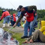 Jamie and Gibson Hill of Sequim pull in a fish while Dave Dewald tries to net it at Kids Fishing Day in 2016. Organizers of the event plan to hold it May 19, 2018, but they hope to move the event to another pond in 2019 to preserve the fish in hot weather. (Matthew Nash/Olympic Peninsula News Group)