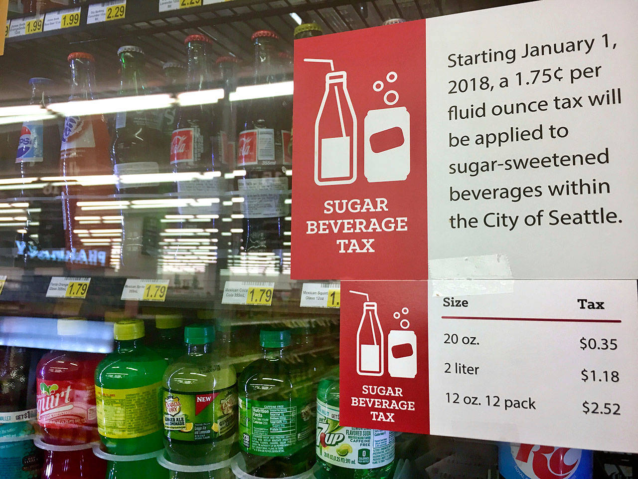 A sign posted on a stores drink cooler Sept. 24 gives information about a soda tax that took effect in January in Seattle. In the wake of Seattles new tax on sugary beverages, a group backed by millions of dollars from the soda industry will ask voters in November whether to prevent other cities and counties in Washington from following suit. Under Initiative 1634, local governments would no longer be able to impose their own taxes on sodas, other sugary beverages and on food items. (Lisa Baumann/The Associated Press)