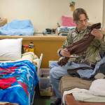 David Everett, a client at the Jefferson County Winter Shelter, tidies up his sleeping area before dinner. (Jesse Major/Peninsula Daily News)