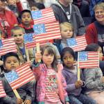 Forks kindergarten students display the colors during the Quillayute Valley School Districts Veterans Day Assembly on Friday afternoon in the Spartan gym. Their teacher, seen to the right, is Karen Wittenborn. Several student speakers, songs, the Quileute Tribe drummers, award presentations, the U.S. Coast Guard color guard school bands honored the many veterans who gathered for the assembly. (Lonnie Archibald/for Peninsula Daily News)