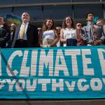In this July 18, file photo lawyers and youth plaintiffs line up behind a banner after a hearing before Federal District Court Judge Ann Aiken between lawyers for the Trump Administration and the so called Climate Kids in Federal Court in Eugene, Ore. (Chris Pietsch/The Register-Guard via AP)