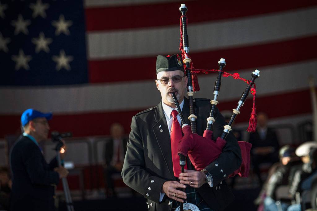 Retired Coast Guardsman Rick McKenzie performs Amazing Grace at the conclusion of the Veterans Day ceremony at U.S. Coast Guard Air Station/Sector Field Office Port Angeles on Sunday. (Jesse Major/Peninsula Daily News)