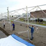 A crew erects a tent Tuesday that will cover a temporary skating rink in a parking lot on the 100 block of West Front Street in Port Angeles. (Keith Thorpe/Peninsula Daily News)