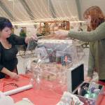 Tree decorators Trish Wray, left, and Brittney Vincent put the finishing touches on a premium package to accompany a Christmas tree sponsored by Swains General Store during final preparations Wednesday for this weekends Festival of Trees at Vern Burton Community Center in Port Angeles. (Keith Thorpe/Peninsula Daily News)