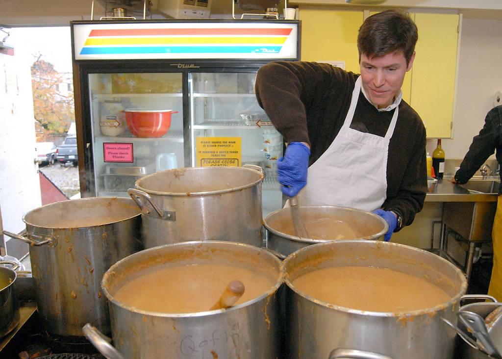 Michael McNulty of Port Angeles stirs pots of gravy at the start of Thursdays community meal in Port Angeles. (Keith Thorpe/Peninsula Daily News)