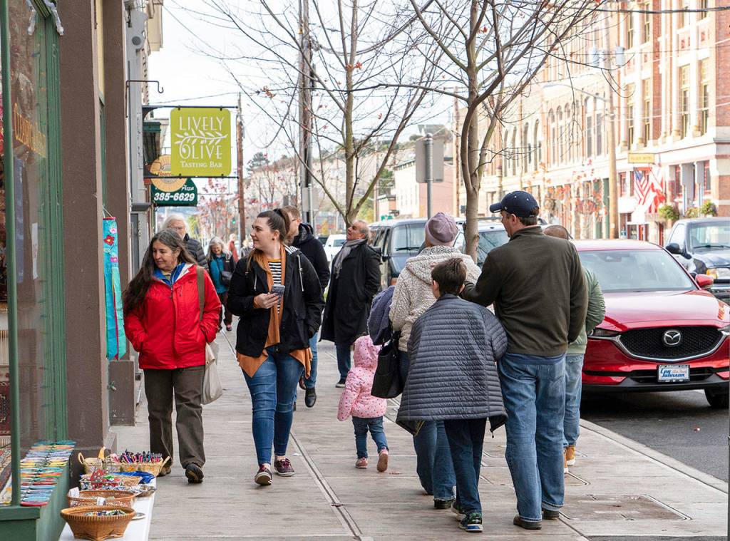 Lee Chavez, left, in red jacket, from Whidbey Island and Maggie Goodall, from Seattle, walk down Water Street in Port Townsend after disembarking from the Coupeville ferry to do some shopping at local businesses during Small Business Saturday. (Steve Mullensky/for Peninsula Daily News)