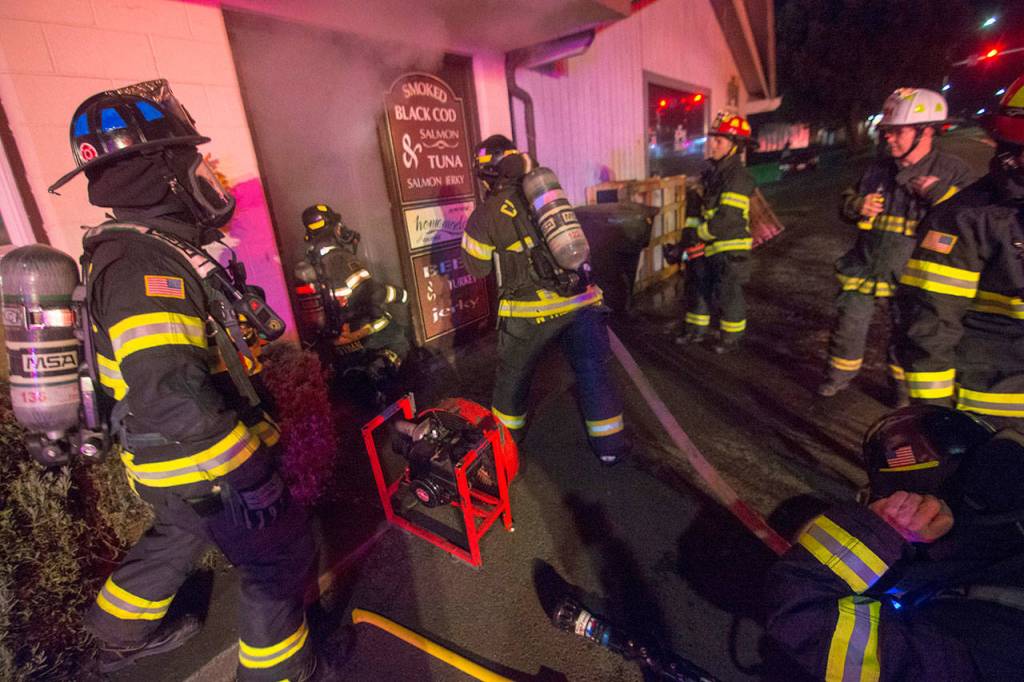 Firefighters prepare to enter Sunrise Meats as they fight a blaze late Saturday night. (Jesse Major/Peninsula Daily News)