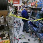 A customer at Anchorage True Value hardware store shops in the partially cleaned up paint aisle after an earthquake Friday morning in Anchorage, Alaska. Tim Craig, owner of the south Anchorage store, said no one was injured but hundreds of items hit the floor and two shelves collapsed in a stock room. (Dan Joling/The Associated Press)