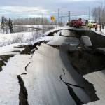 A tow truck holds a car that was pulled from on an off-ramp that collapsed during a morning earthquake Friday in Anchorage, Alaska. The driver was not injured attempting to exit Minnesota Drive at International Airport Road. (Mike Dinneen/The Associated Press)