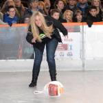Jen Swanson, marketing manager for First Federal, tosses a frozen turkey down the ice in a round of turkey curling during Friday nights official grand opening of the Port Angeles Winter Ice Village. (Keith Thorpe/Peninsula Daily News)