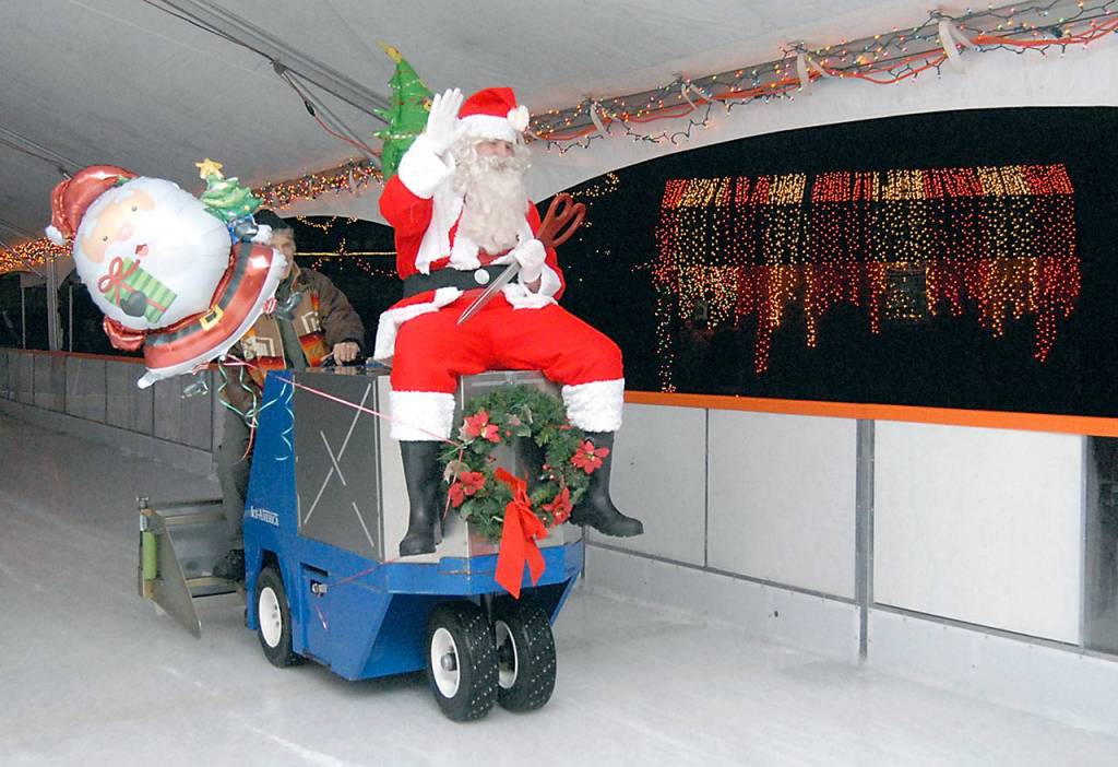Santa Claus, portrayed by Cole Walsh, arrives on an ice resurfacing machine carrying scissors to cut the ribbon during Fridays official opening of the Port Angeles Winter Ice Village. (Keith Thorpe/Peninsula Daily News)