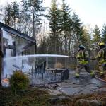 Firefighter/Paramedic Erik Payne and Firefighter/EMT John McKenzie battle flames on a Blyn homes deck Monday. (Matthew Nash/Olympic Peninsula News Group)