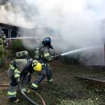 Clallam County firefighters attempt to combat flames on a Blyn house fire Monday. (Matthew Nash/Olympic Peninsula News Group)