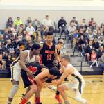 Lonnie Archibald/for Peninsula Daily News                                Forks Trey Baysinger (left) and Joseph Reaume trap Neah Bays Cameron Moore during the Spartans 67-64 win over Neah Bay on Wednesday.
