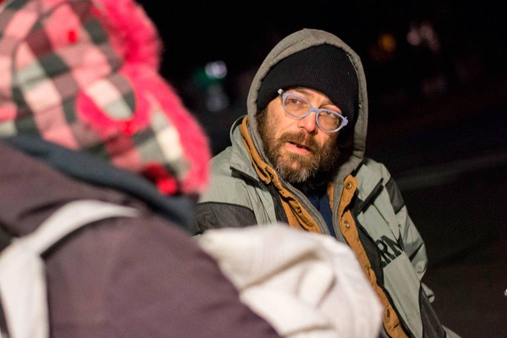 Mike Hollingsworth, who has been homeless for about four years, talks with Amy Miller and Shenna Younger outside Salvation Army in Port Angeles early Thursday morning. (Jesse Major/Peninsula Daily News)