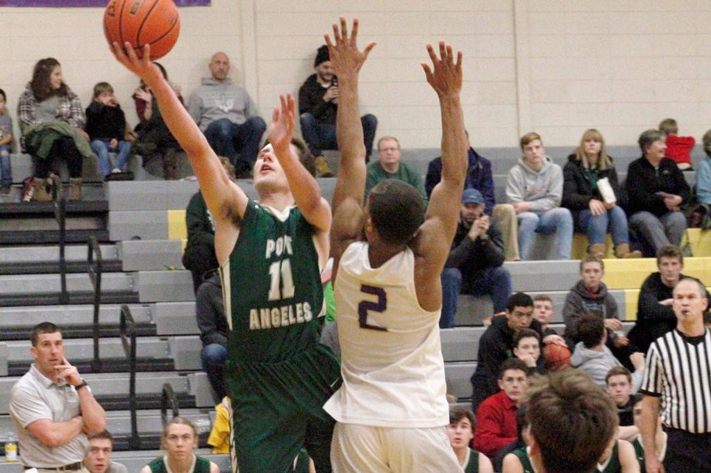 Mark Krulish/Kitsap News Group Port Angeles Kyle Benedict goes up for a layup while defended by North Kitsaps Kobe McMillian. Benedict led the Riders with 14 points in a 58-54 loss to the Vikings.