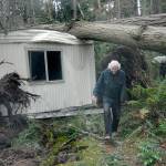 Dave Becker emerges from the wreckage of his mobile home after it and an adjoining structure were crushed by falling trees in the Old Mill Road area south of Port Angeles on Friday. (Keith Thorpe/Peninsula Daily News)
