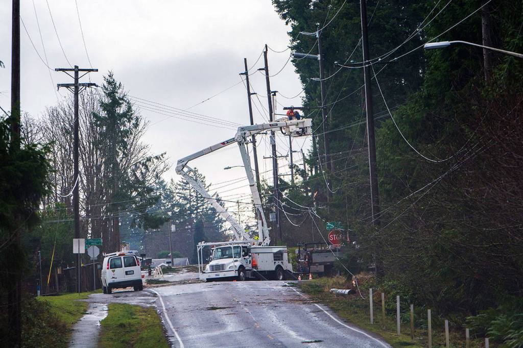 Linemen work on power lines at Park Avenue and Race Street on Sunday in Port Angeles. (Jesse Major/Peninsula Daily News)