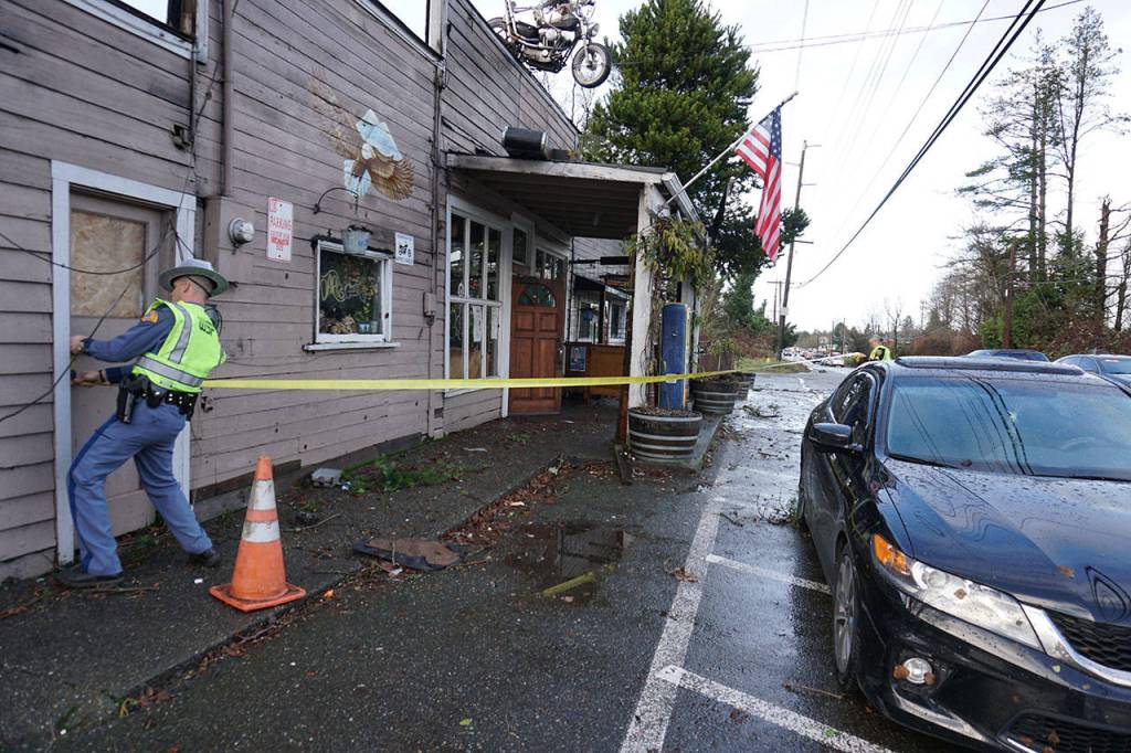 A State Patrol trooper cordons off an area in front of the Bethel Saloon, damaged by a freak tornado that swept through the eastern part of Port Orchard. (Bob Smith/Kitsap News Group)