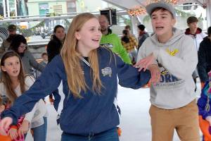 Keith Thorpe/Peninsula Daily News Kadie Wood, left, and Grady Earls, both 13 of Forks, enjoy an afternoon skating on Saturday at the Port Angeles Winter Ice Village in downtown Port Angeles.