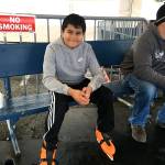 Emilio Lopez, 11, rests after skating at the Port Angeles Winter Ice Village with his sister, Leny, and aunt, Noreen, on Monday. Sam Davies of Port Angeles is seated on the right. (Rob Ollikainen/Peninsula Daily News)
