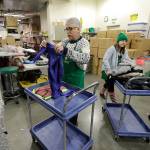 Chris Meyer, left, and Maddi Heim, fold and sort donated clothes Dec. 21 at Treehouse, a nonprofit organization in Seattle that serves the needs of children in the foster-care system. (Ted S. Warren/The Associated Press)