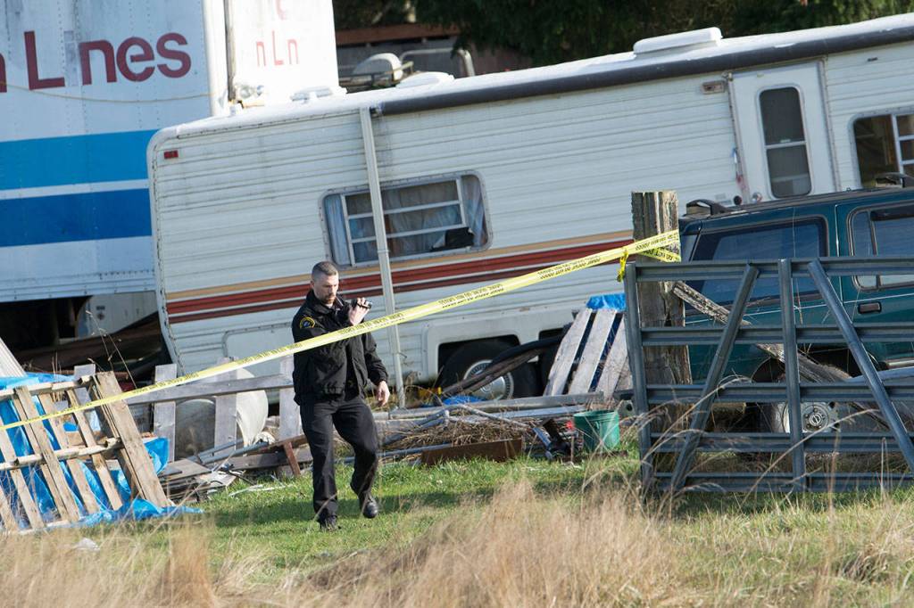 Investigators document the crime scene at a property on Bear Meadow Road where three bodies have been found. (Jesse Major/Peninsula Daily News)