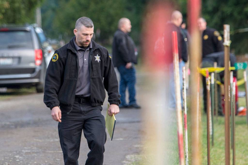 Clallam County Sheriffs Det. Josh Ley walks away from the scene were three people were killed. (Jesse Major/Peninsula Daily News)