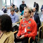 Anti-tax activist Tim Eyman, right, wears a sweatshirt with stickers from his I-976 $30 car tabs initiative on it as he attends the Associated Press Legislative Preview on Thursday at the Capitol in Olympia. (Ted S. Warren/The Associated Press)