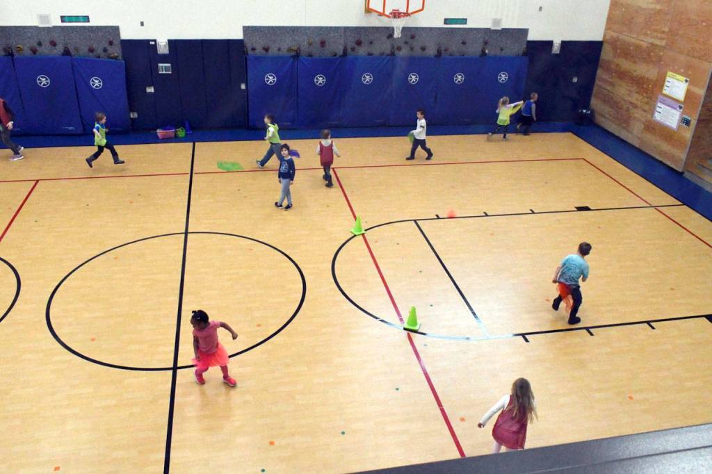 Students take part in exercise time in the Salish Coast gym, which can be seen from a set of windows in a hallway above the action. The new school has plenty of outdoor space for physical activity, too, as well as a mud room to clean off when its time to go back to class. (Jeannie McMacken/Peninsula Daily News)