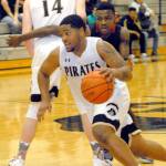 Keith Thorpe/Peninsula Daily News Peninsulas Davien Harris-Williams, front, takes advantage of a screen set by teammate Erik Kelly to evade Skagit Valleys Mubarak Michael during the first half on Wednesday on Port Angeles.