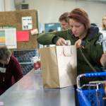 Ashley Gamble, whose husband serves in the U.S. Coast Guard, goes through the Port Angeles Food Bank during a special distribution for families of federal workers who have been affected by the government shutdown. (Jesse Major/Peninsula Daily News)