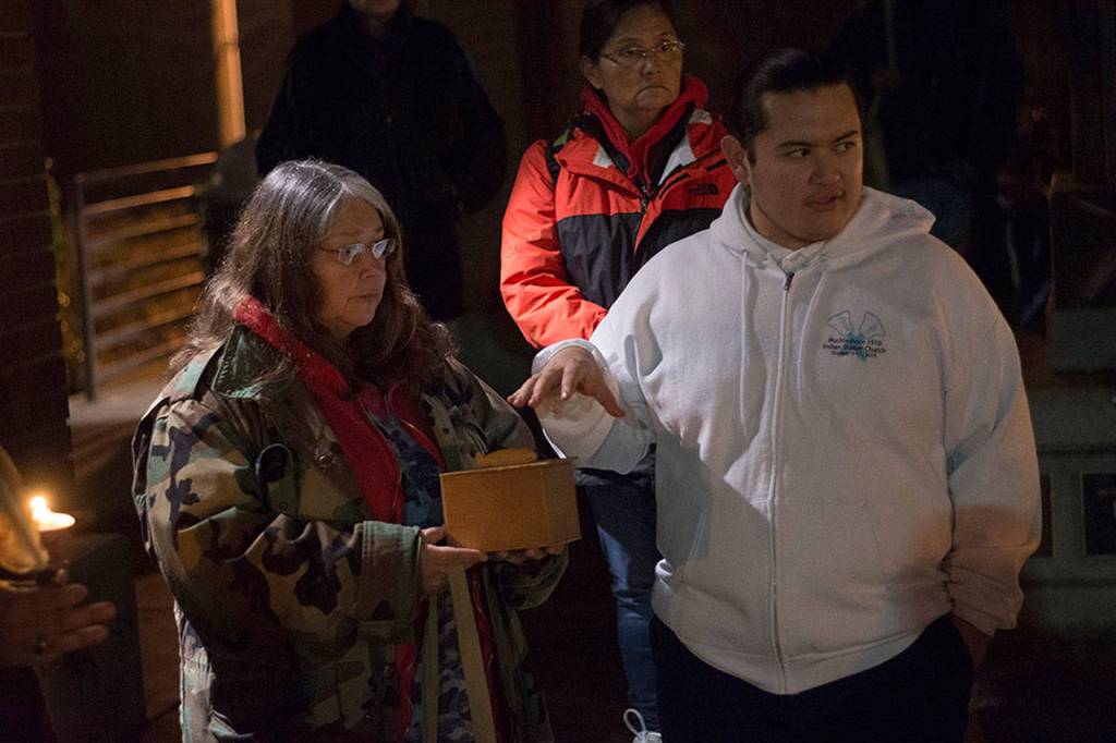 Cindy Claplnahoo, left, hands out gifts from her family during a vigil for her sister, Valerie Claplanhoo, who was killed in Sequim on Jan. 2. (Jesse Major/Peninsula Dialy News)