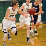 <strong>Keith Thorpe</strong>/Peninsula Daily News                                Port Angeles Payton Schmidt, left, grabs a loose ball and drives down court followed by teammates Gabriel Long and Liam Clark, right, and Olympics Greg Brehmer on Friday night at Port Angeles High School.