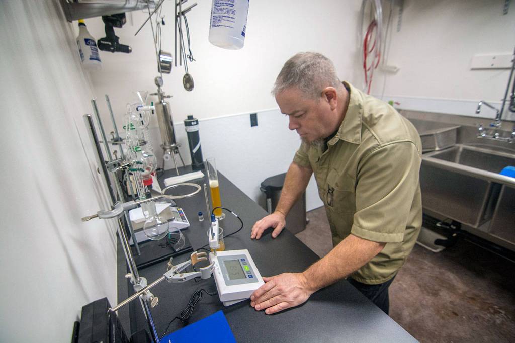 Eric Reeter, co-owner of The Mead Werks meadery in Port Townsend, tests the pH of one of the meads. (Jesse Major/Peninsula Daily News)