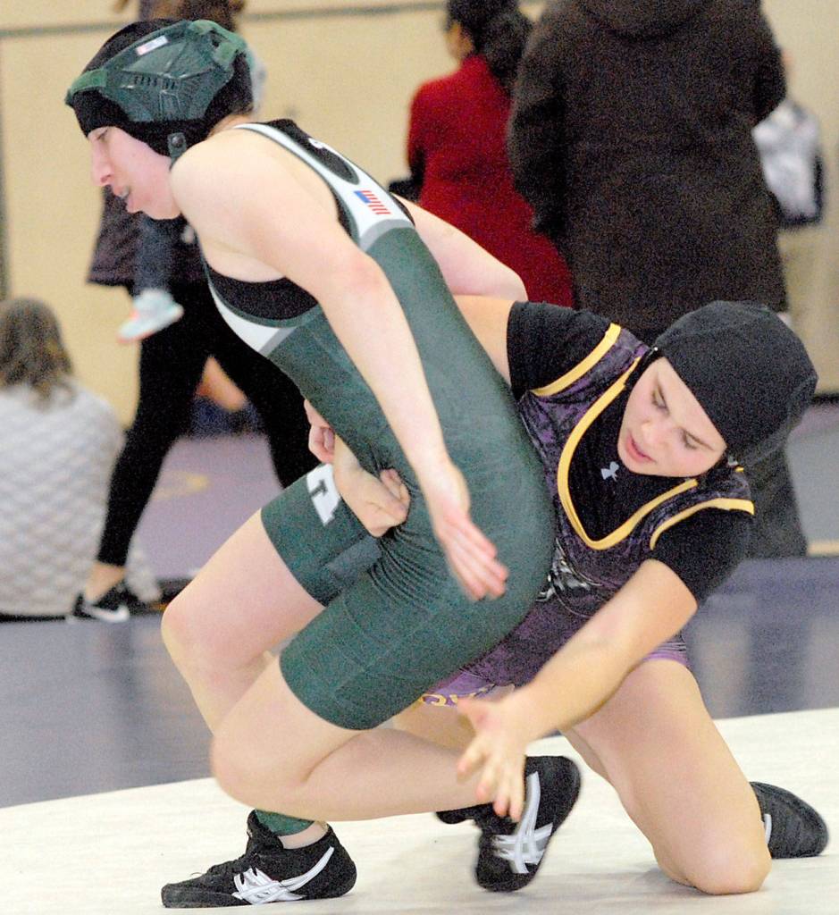 Keith Thorpe/Peninsula Daily News Trinity Laws of Port Angeles, left, tries to escape the grasp of Sequims Alexi Rampp-Taft in the 120 lb. weight class during Saturdays sub-regional tournament.