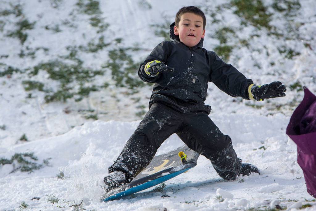 Tryton Bondy, 9, of Port Angeles loses control of his sled after going over a jump at the bottom of a hill at Stevens Middle School on Monday. (Jesse Major/Peninsula Daily News)