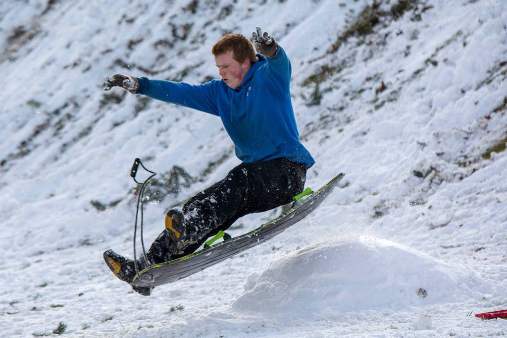 Michael Emery goes over a jump at the bottom of a hill at Stevens Middle School in Port Angeles on Monday. (Jesse Major/Peninsula Daily News)