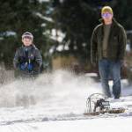 Brian Winters watches on as his 9-year-old son Cole uses a remote controlled air boat at the snow-covered field at Stevens Middle School in Port Angeles on Sunday. (Jesse Major/Peninsula Daily News)