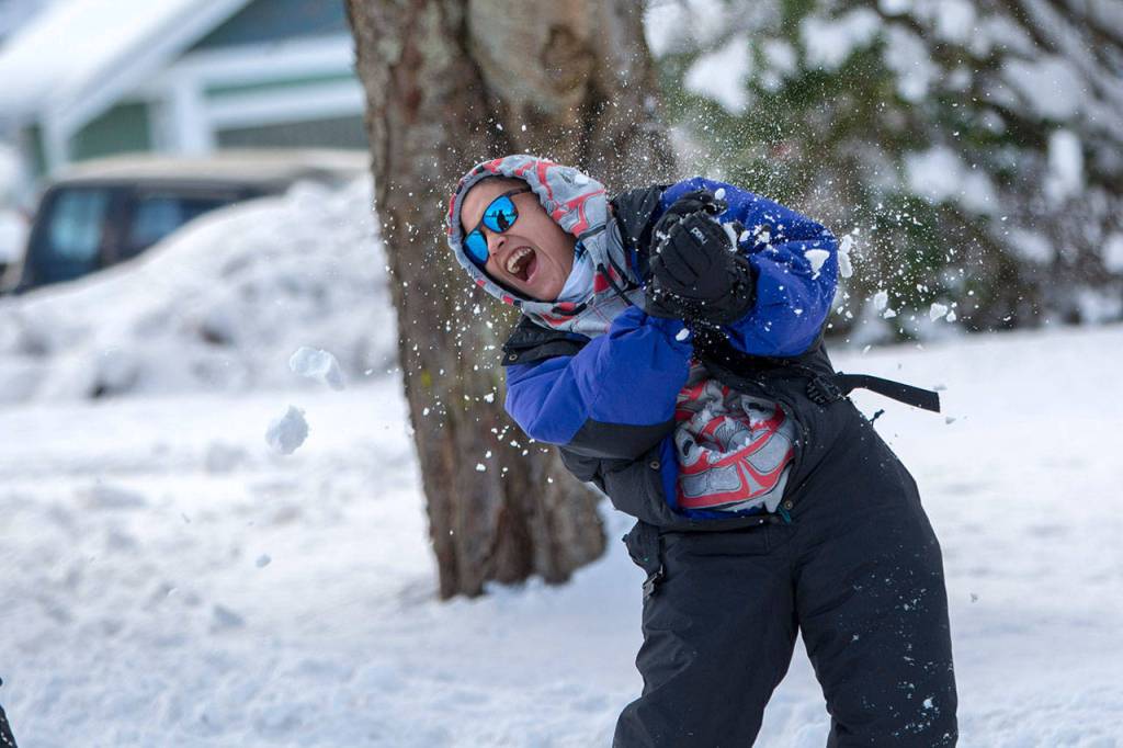 Lindsey Mike reacts after being hit with a snowball at a community snowball fight in Port Angeles on Sunday. (Jesse Major/Peninsula Daily News)