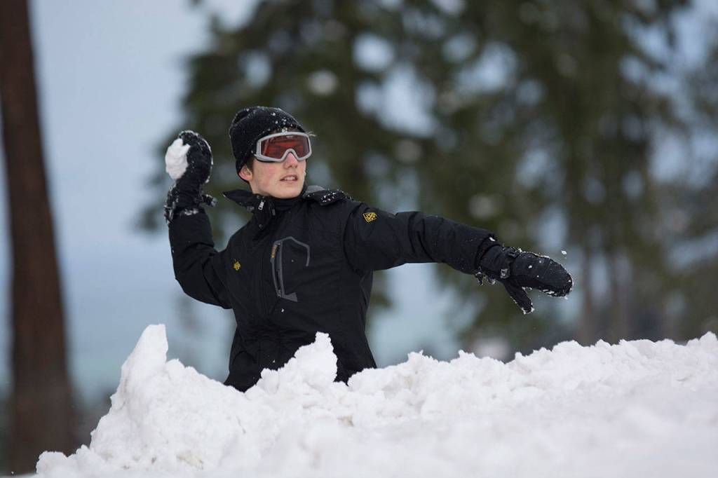 Hiding behind a snow fort, Loren Dahlin, 16, takes aim during a community snowball fight in Port Angeles on Sunday. (Jesse Major/Peninsula Daily News)